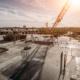 Roof of construction site of new multi-storey residential building, industrial construction crane and other industry equipment
